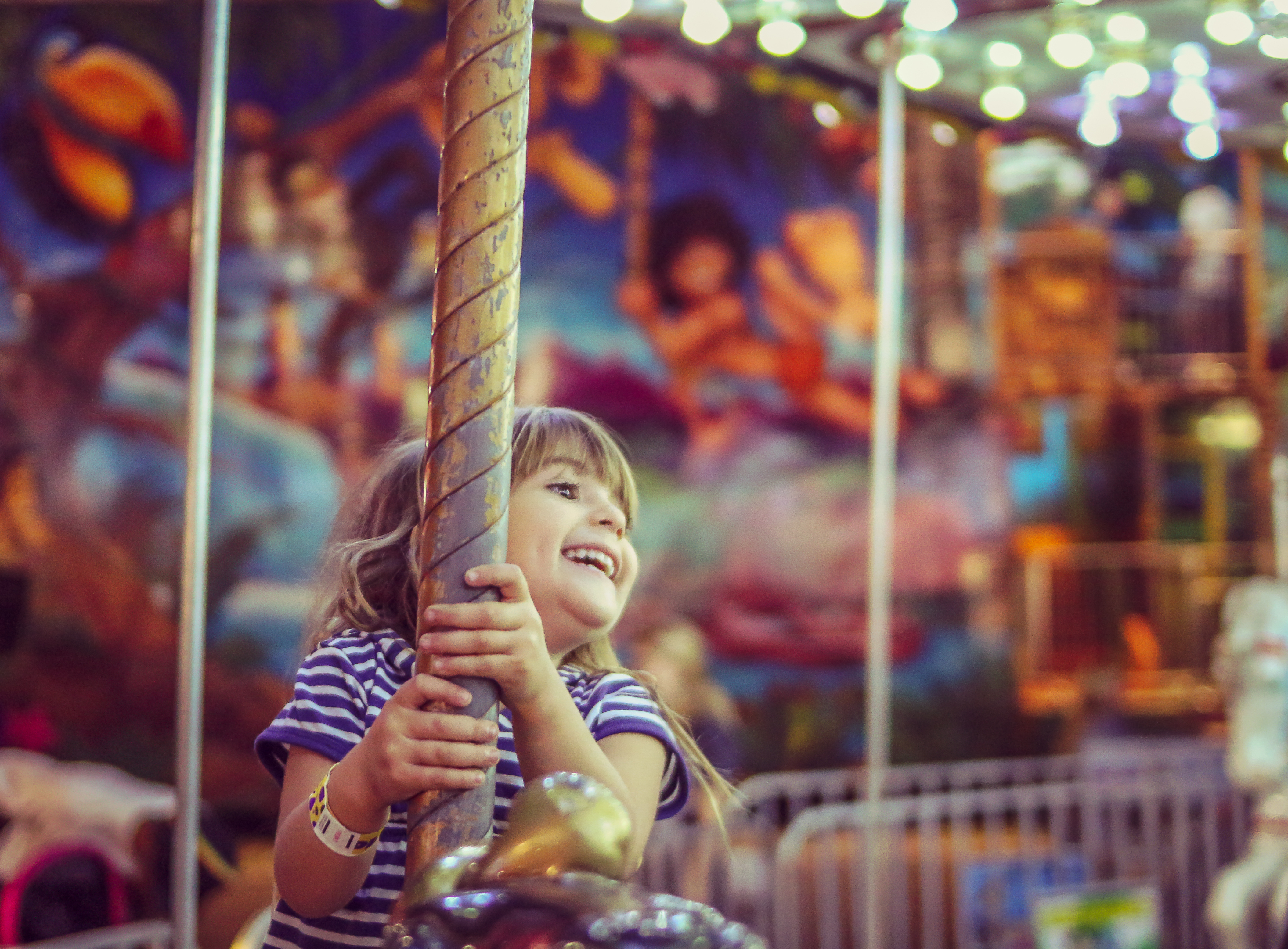 A child laughing with joy on a carousel ride